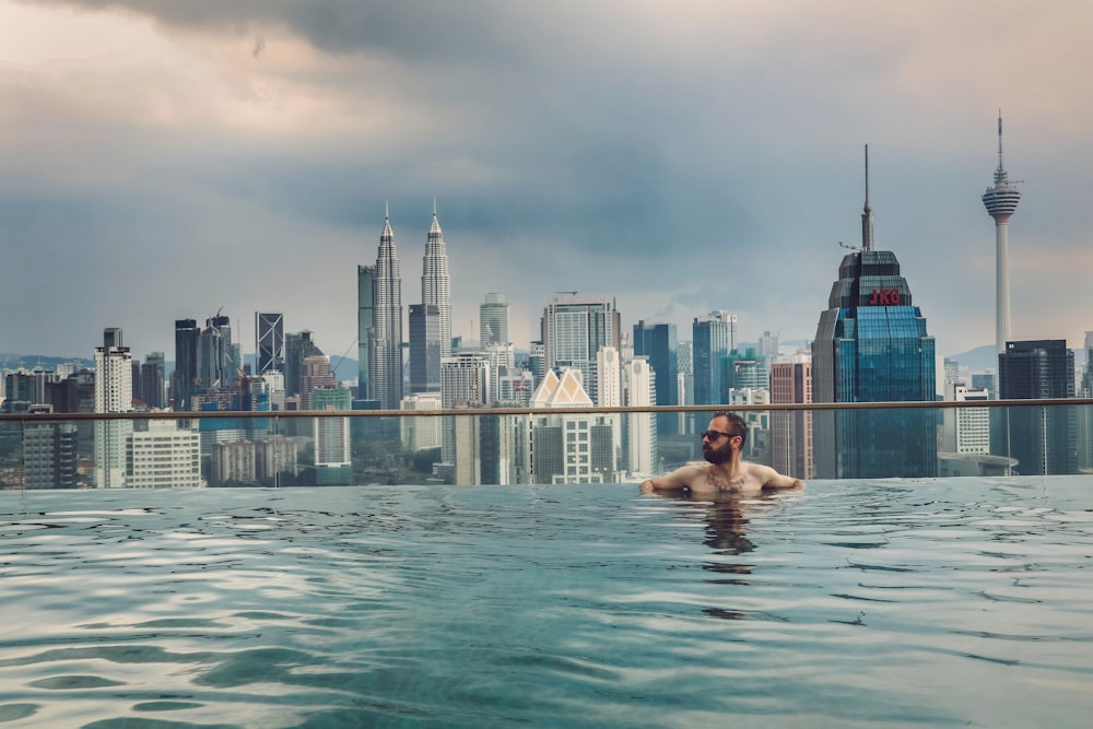 man swimming in building rooftop pool