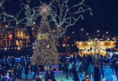 A lively outdoor ice skating rink filled with families and colorful holiday decorations.