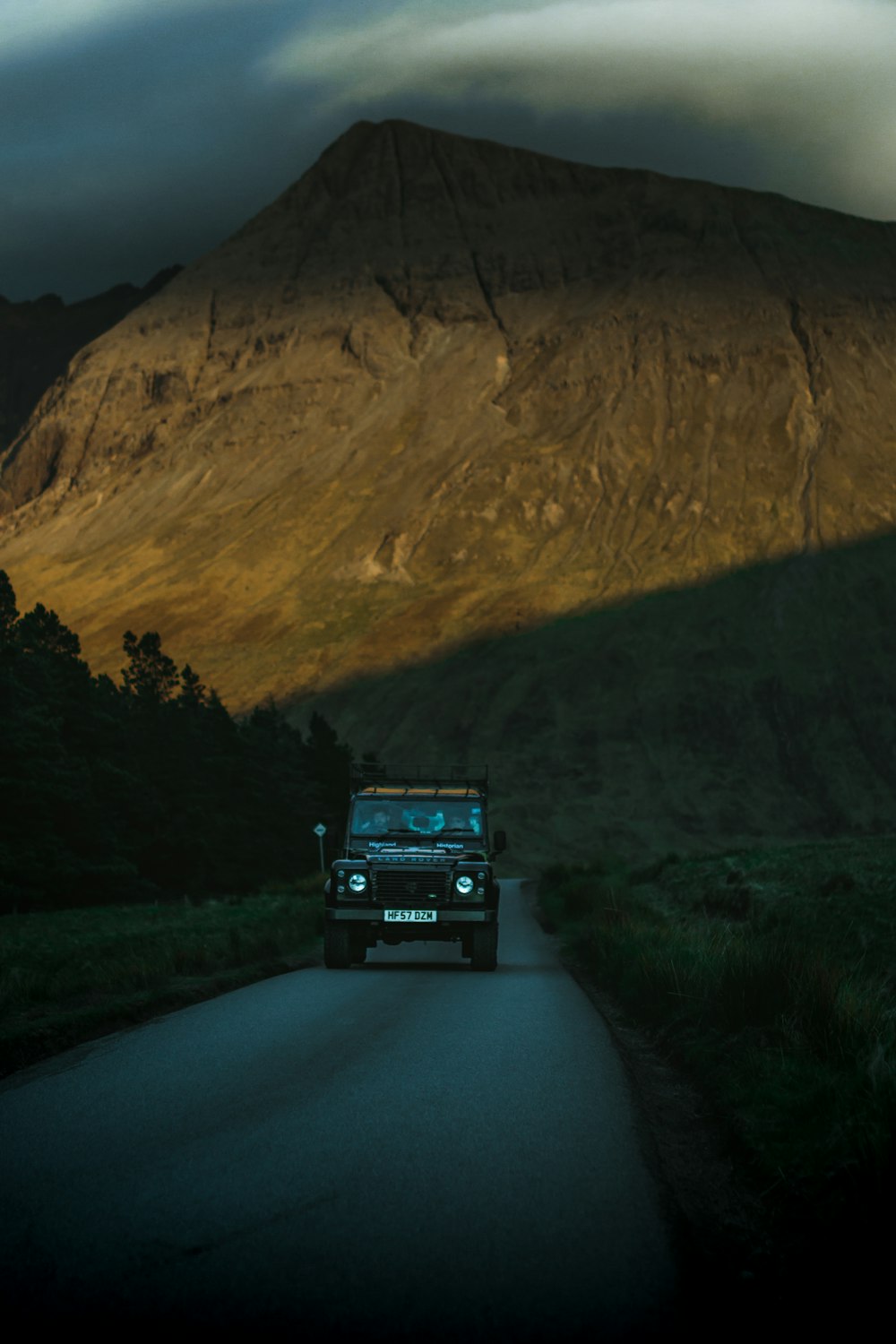 grey Land Rover Defender in country road