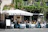 Sunlit terrace with people enjoying colorful aperitifs and fresh pastries at Vitadolce.