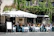 Sunlit terrace with people enjoying colorful aperitifs and fresh pastries at Vitadolce.