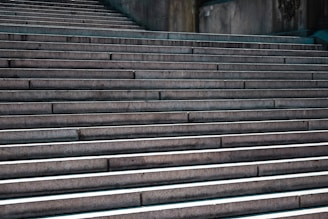 A series of wide, concrete steps leading upward, with shadows accentuating the edges. The steps create a rhythmic pattern and convey a sense of progression and ascent.