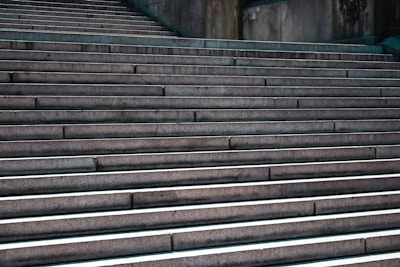 A series of wide, concrete steps leading upward, with shadows accentuating the edges. The steps create a rhythmic pattern and convey a sense of progression and ascent.