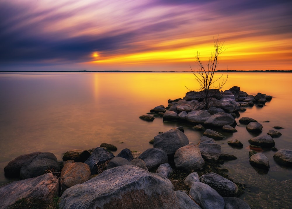 brown boulder rocks with body of water