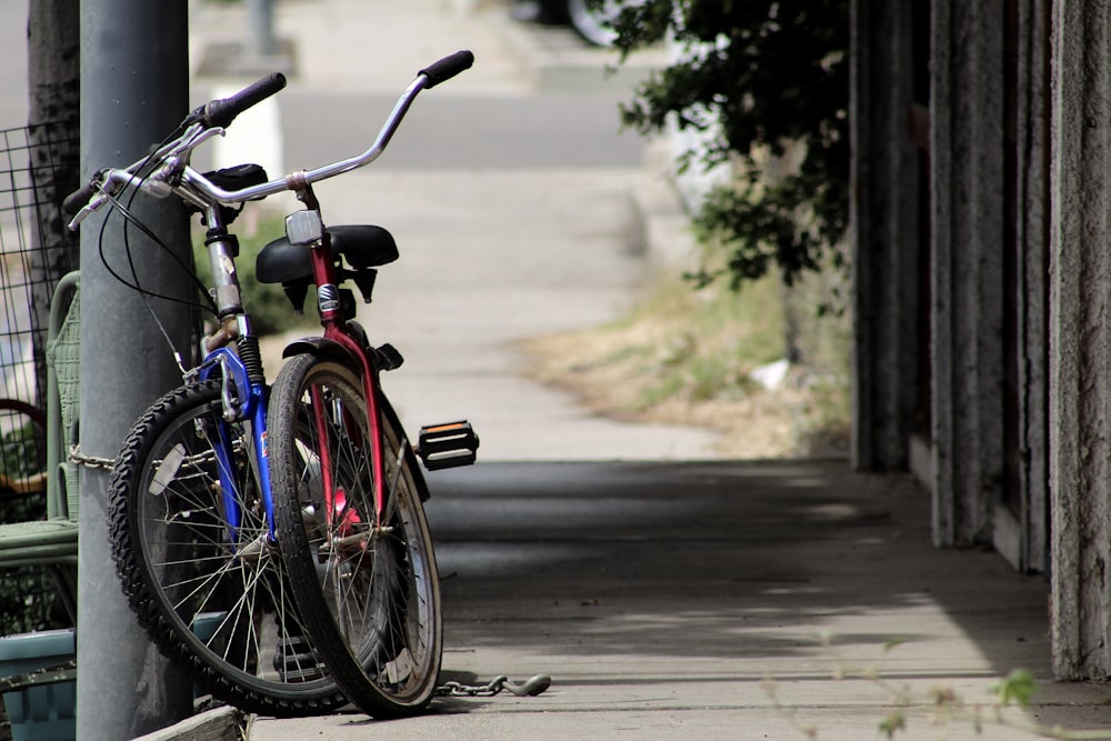 two blue and red bicycles parked on street