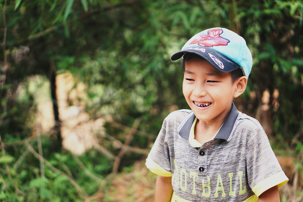 laughing boy standing near trees