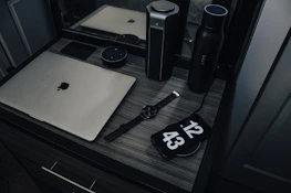 A modern desk setup featuring smart speakers, tablets, and wearable tech.