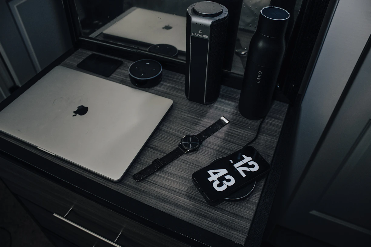 A sleek, modern workspace with smartwatches and tech gadgets displayed on a dark-themed desk.