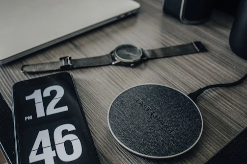 A modern CEO’s desk featuring a holographic calendar and sleek wireless charging station.