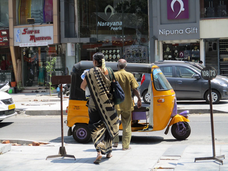 People approaching an auto-rickshaw in India