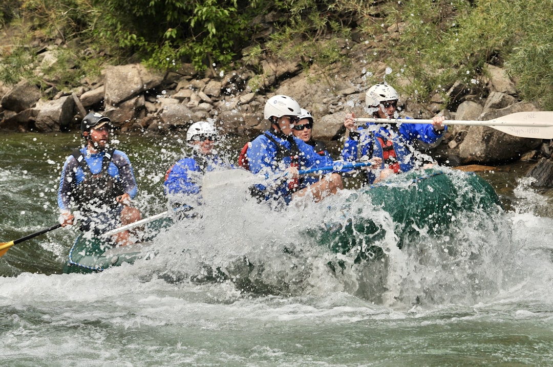 five people rafting on river,