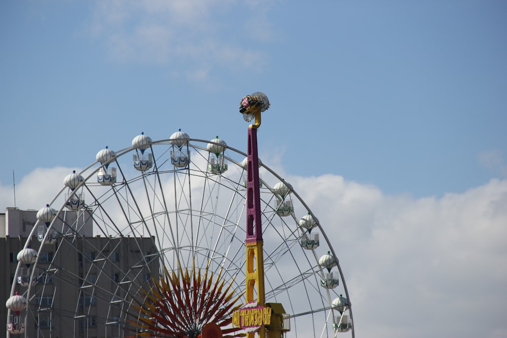 metal tower beside ferris wheel during daytime