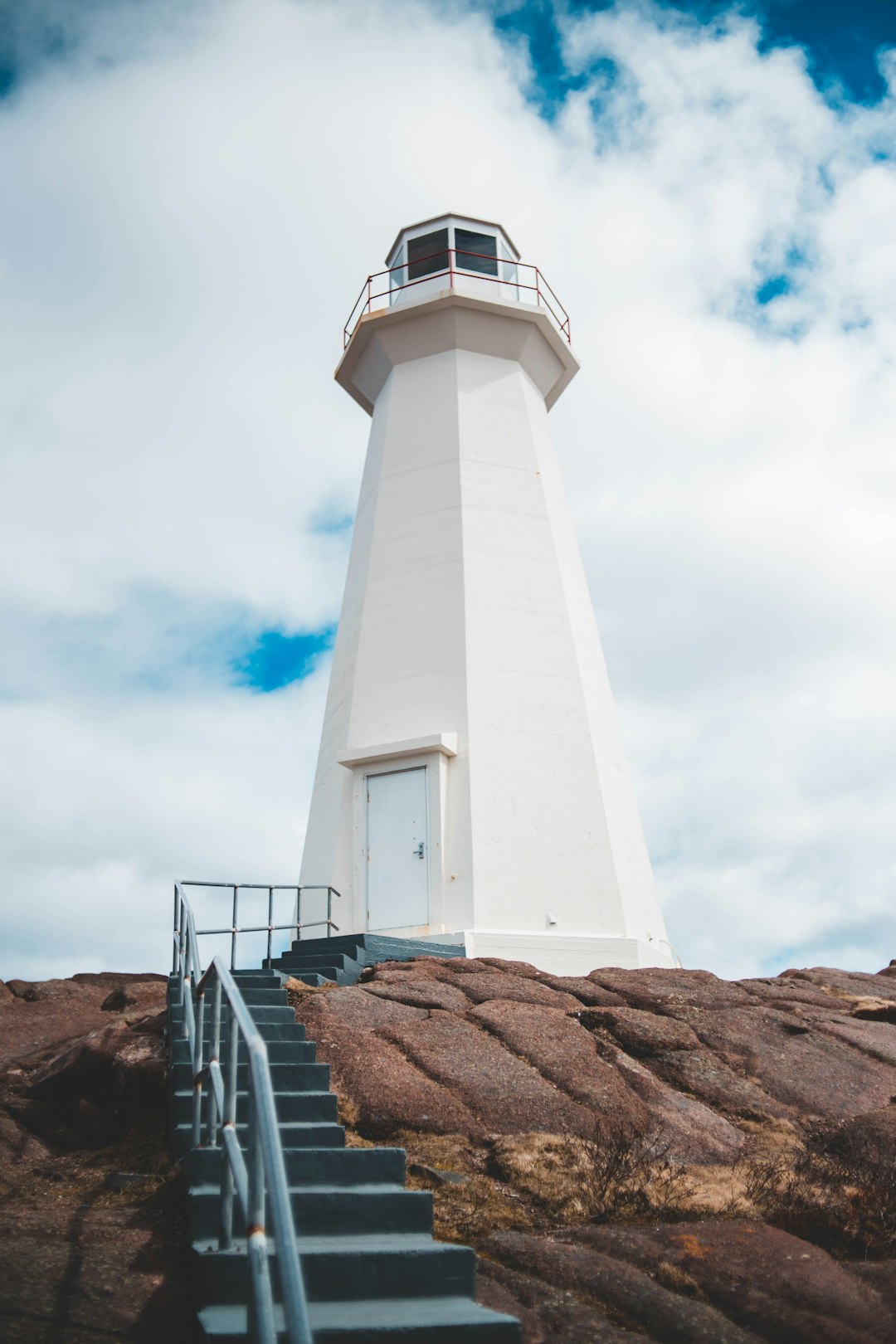 empty stairs going towards white concrete lighthouse at daytime