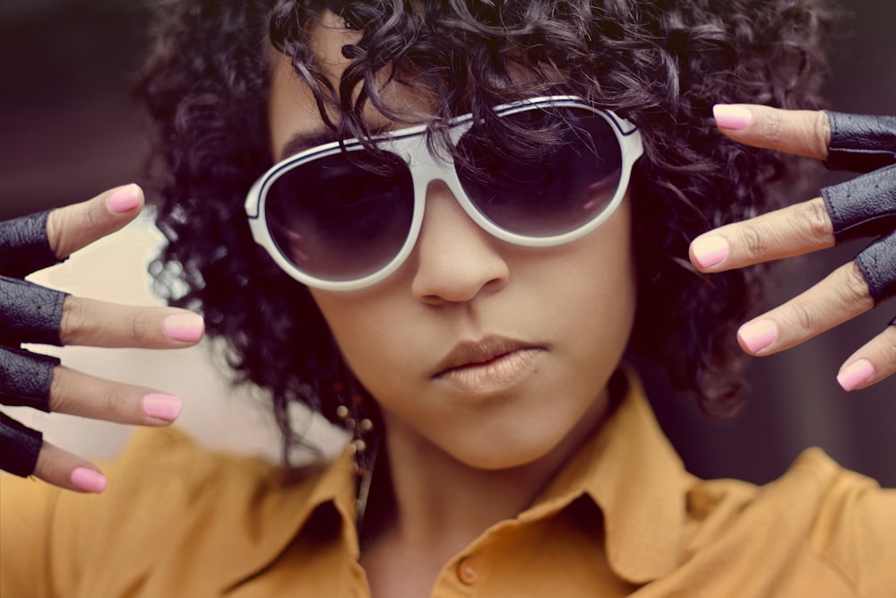 woman wearing sunglasses and showing both hands