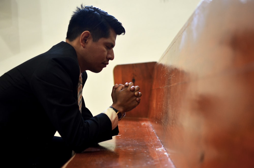 man sitting, closing his eyes and praying