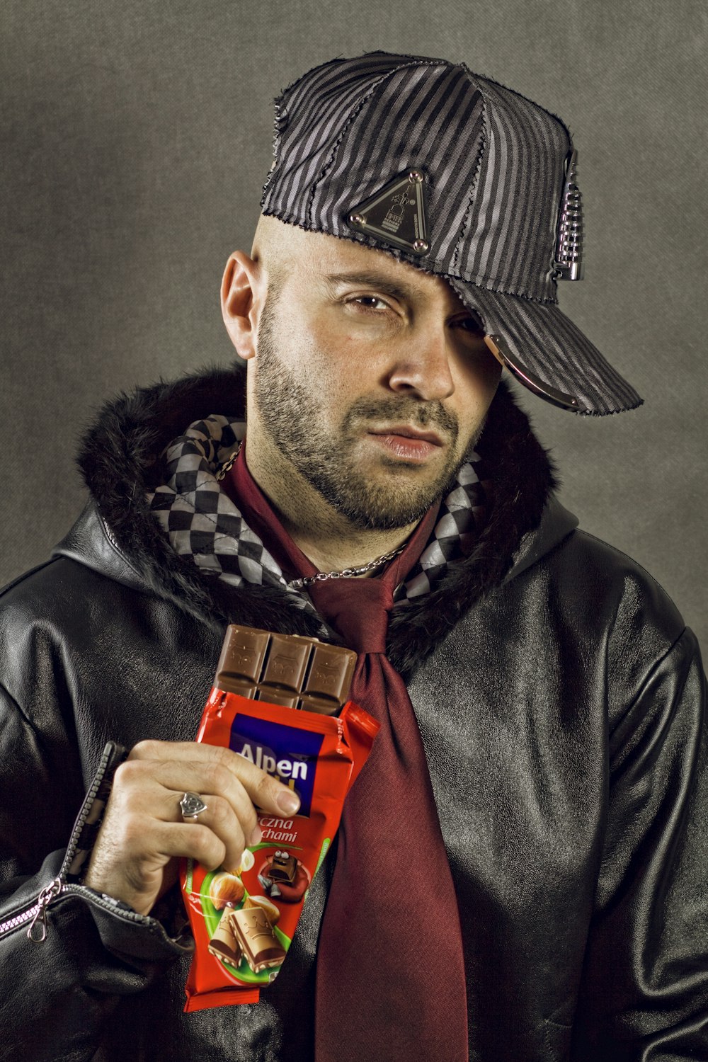 man in black leather jacket with red Alpen chocolate bar pack in hand