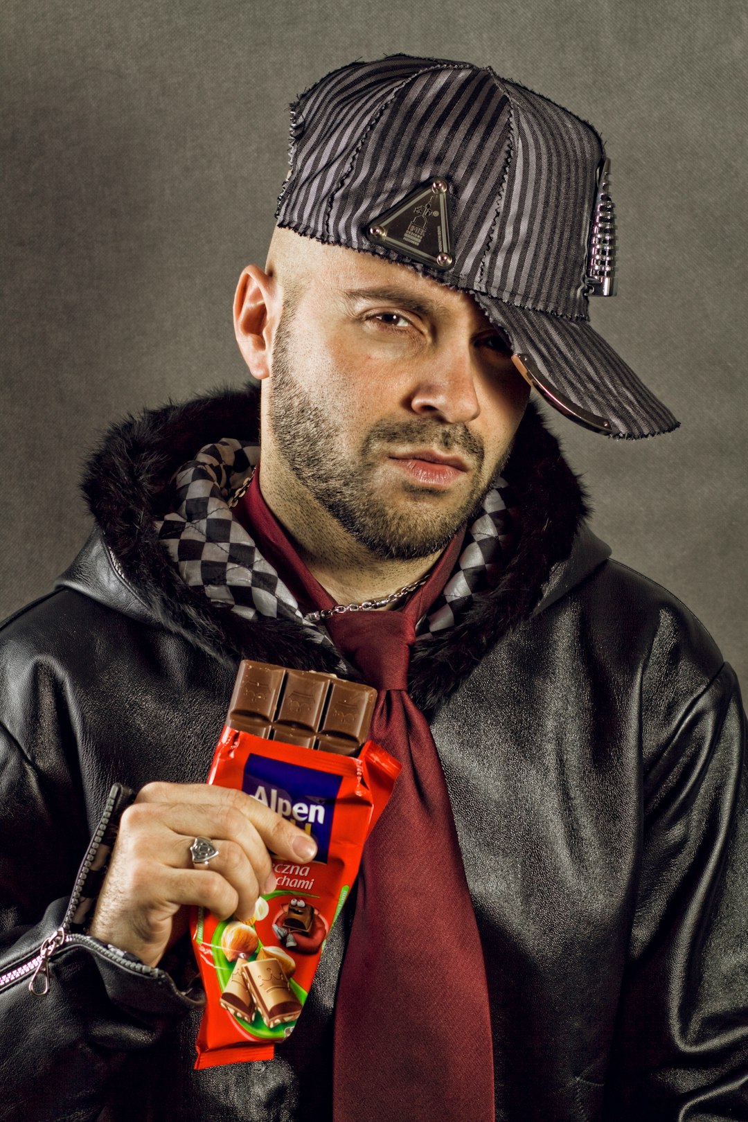 man in black leather jacket with red Alpen chocolate bar pack in hand