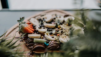 Close-up of tropical bite-size desserts arranged on a rustic wooden table with vibrant island fruits.