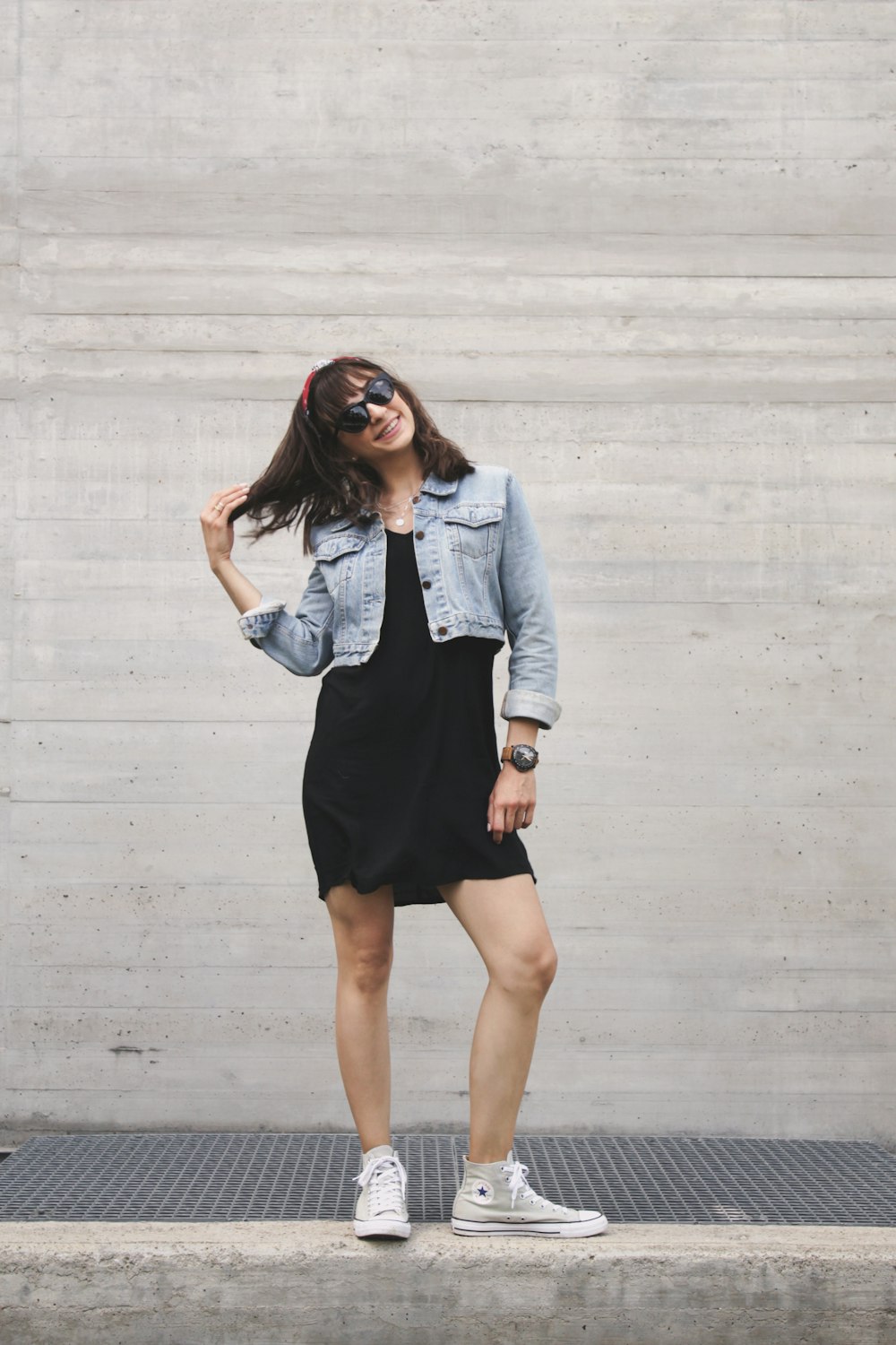 Mujer con vestido negro y chaqueta vaquera azul