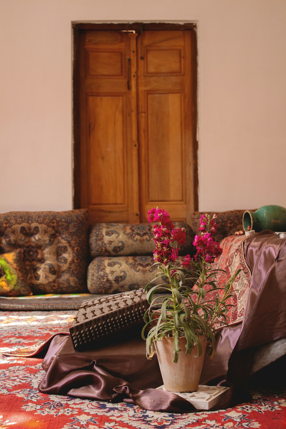 pink flower in pot on floor