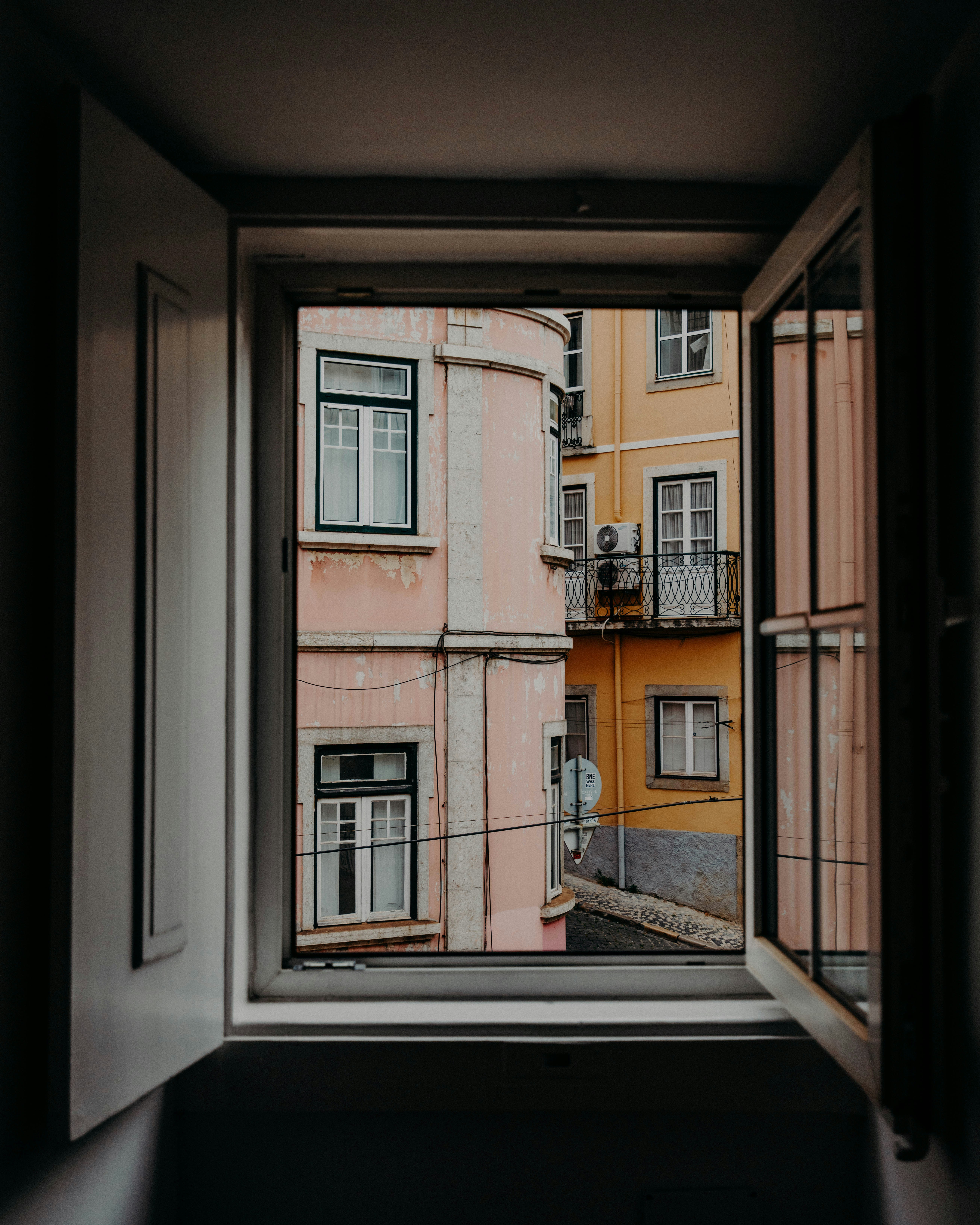 wooden window opened with view of concrete buildings