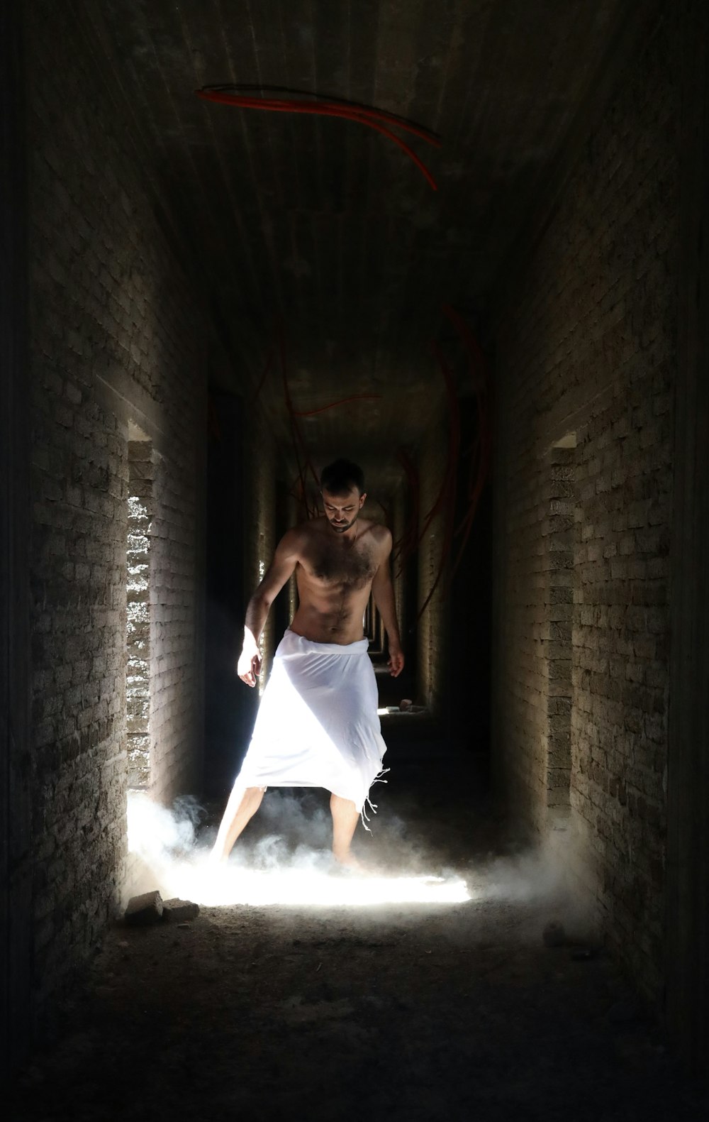 man wearing white shirts in the middle of hallway