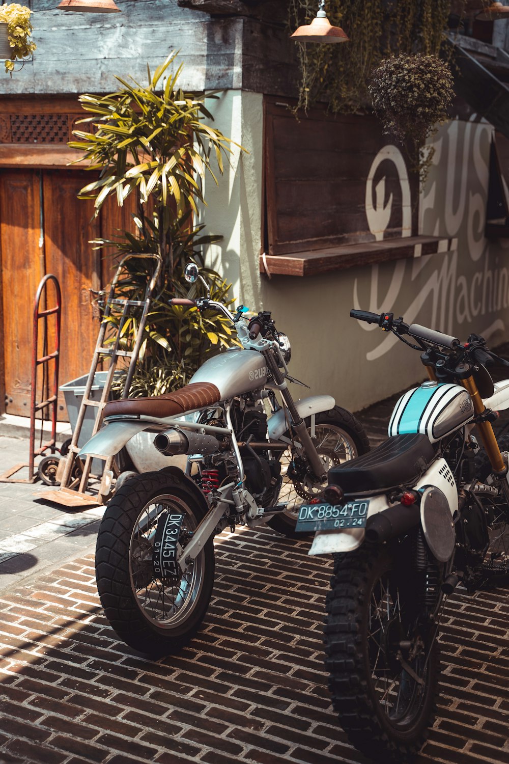 two standard motorcycles near hand truck