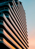 Modern residential building exterior at sunset with sleek architectural lines.