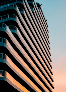 Sunset view of a completed residential building with clean lines and rich blue accents highlighting the structure.