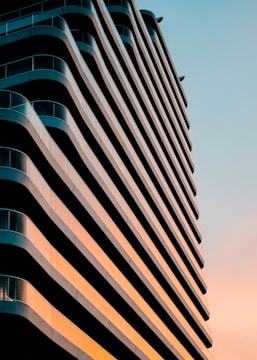 Modern residential building showcasing sleek architectural lines at sunset.
