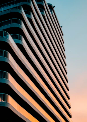 Wide shot of a sleek modern residential building at sunset, showcasing clean lines and refined architecture.