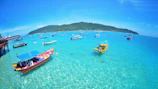 A vibrant beach scene with turquoise waters and traditional fishing boats.