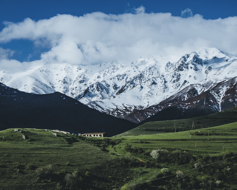 snow-covered mountain near house during daytime