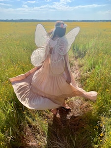 woman in fairy costume standing on green field