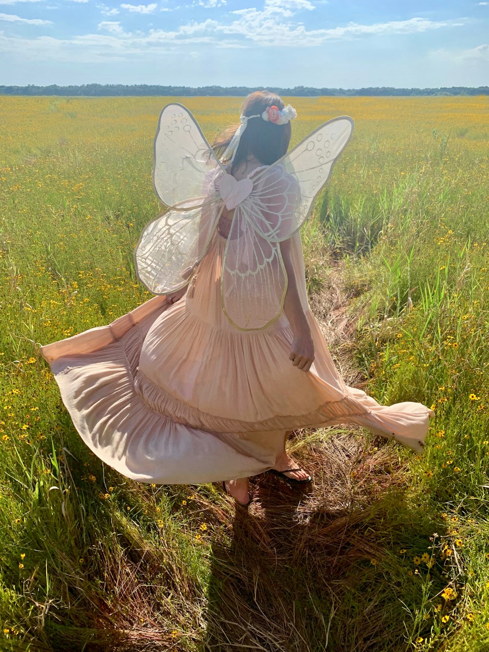 woman in fairy costume standing on green field