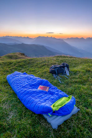 blue sleeping bag on mountain during daytime