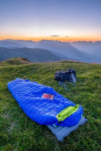 blue sleeping bag on mountain during daytime