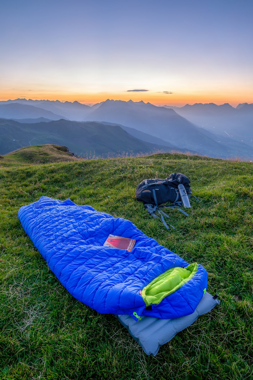 blue sleeping bag on mountain during daytime