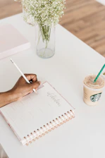 person writing on notebook