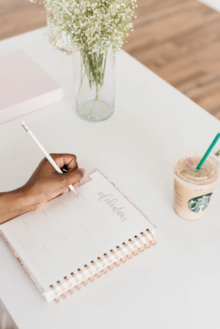 person writing on notebook