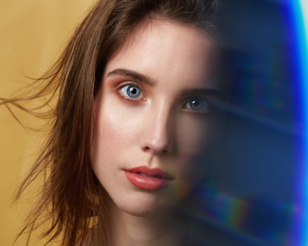 A striking portrait of a young woman with vibrant background blur, highlighting her expressive eyes.