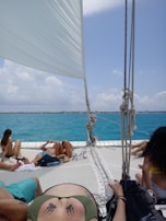 A group of friends celebrating on a sailboat deck.