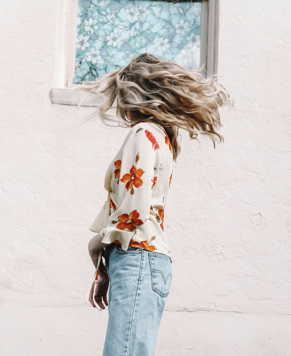 woman standing and waving her head near white building