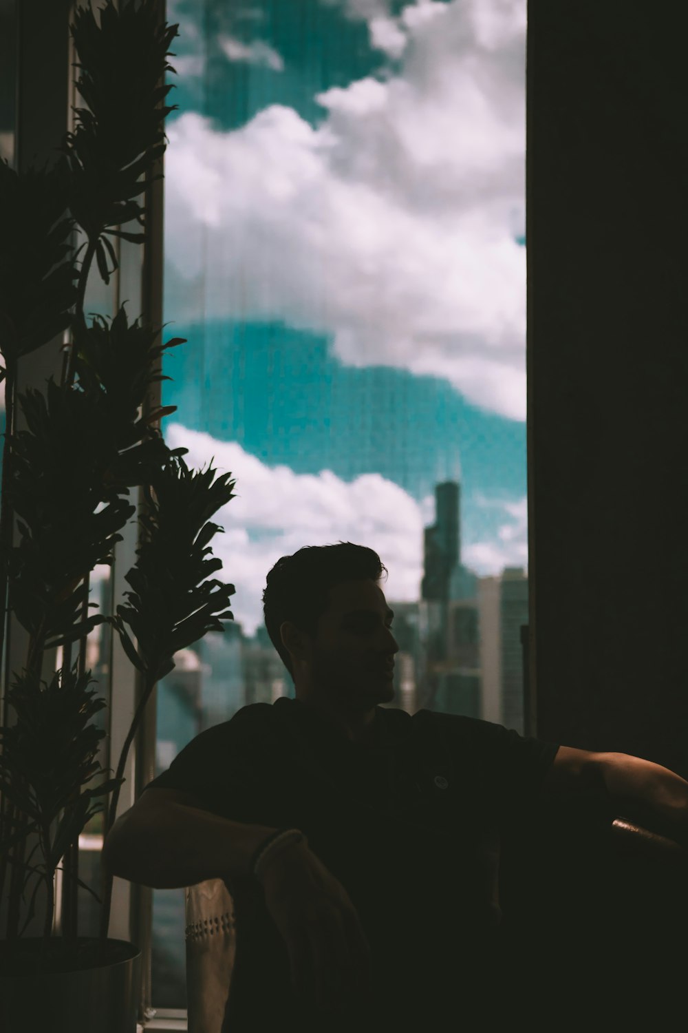 a man sitting in a chair in front of a window