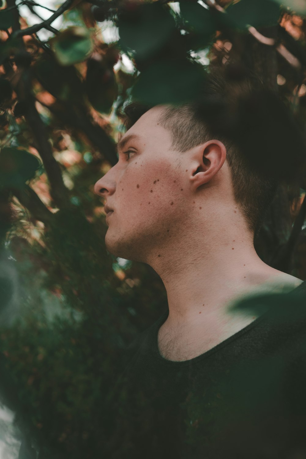 man wearing black shirt beside tree