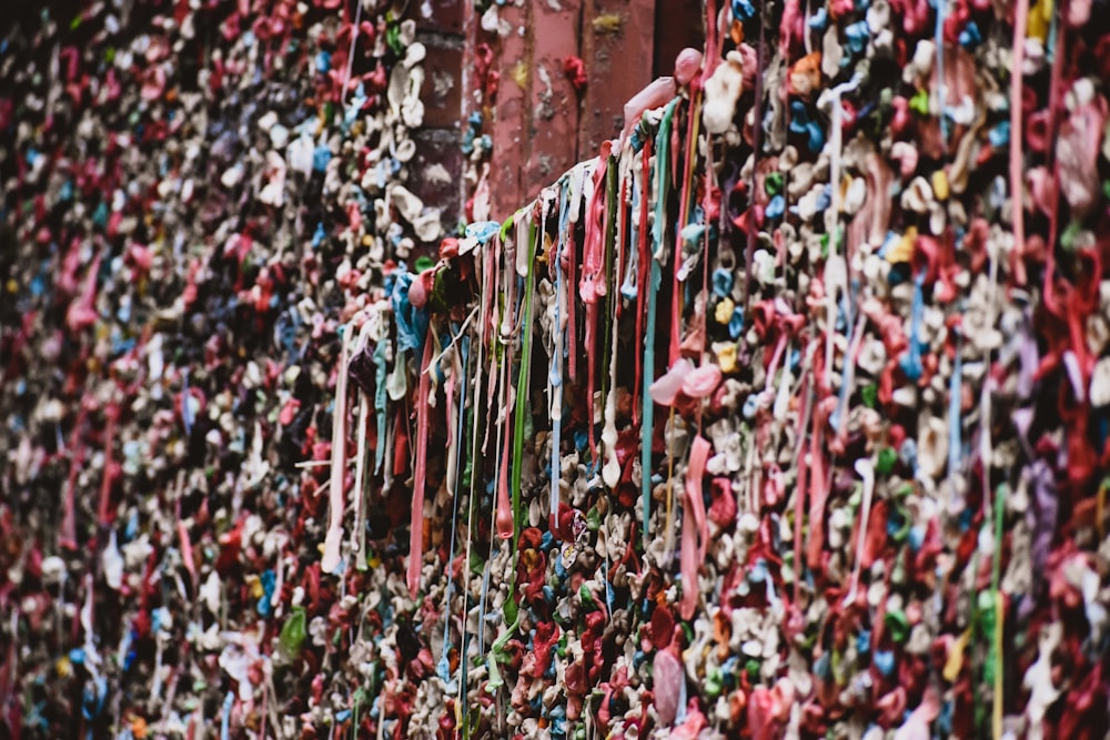 un mur recouvert de nombreux rubans de couleurs différentes