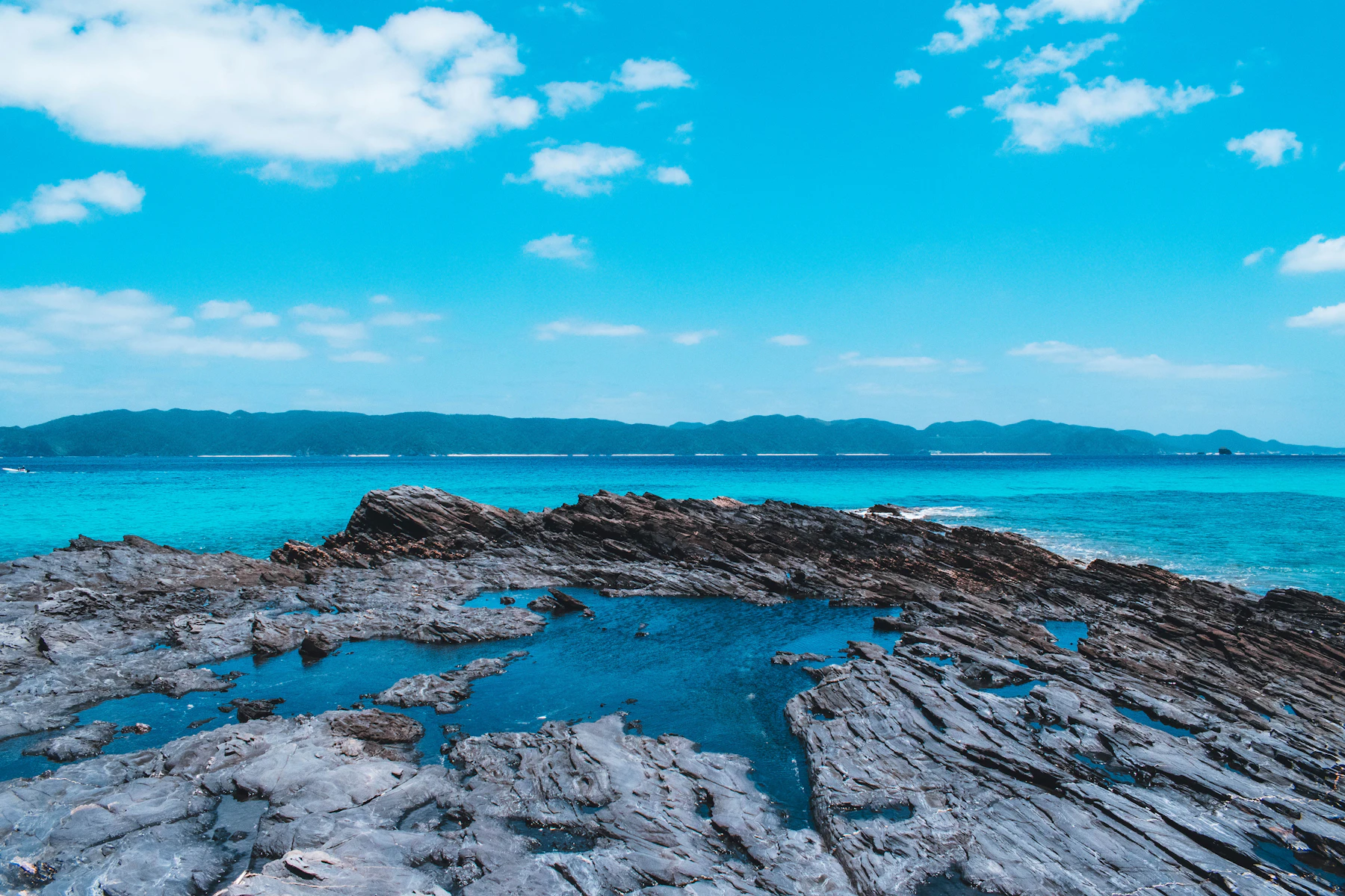 Felsige Küste und tiefblaues Meer im grünen Norden der Okinawa-Hauptinsel