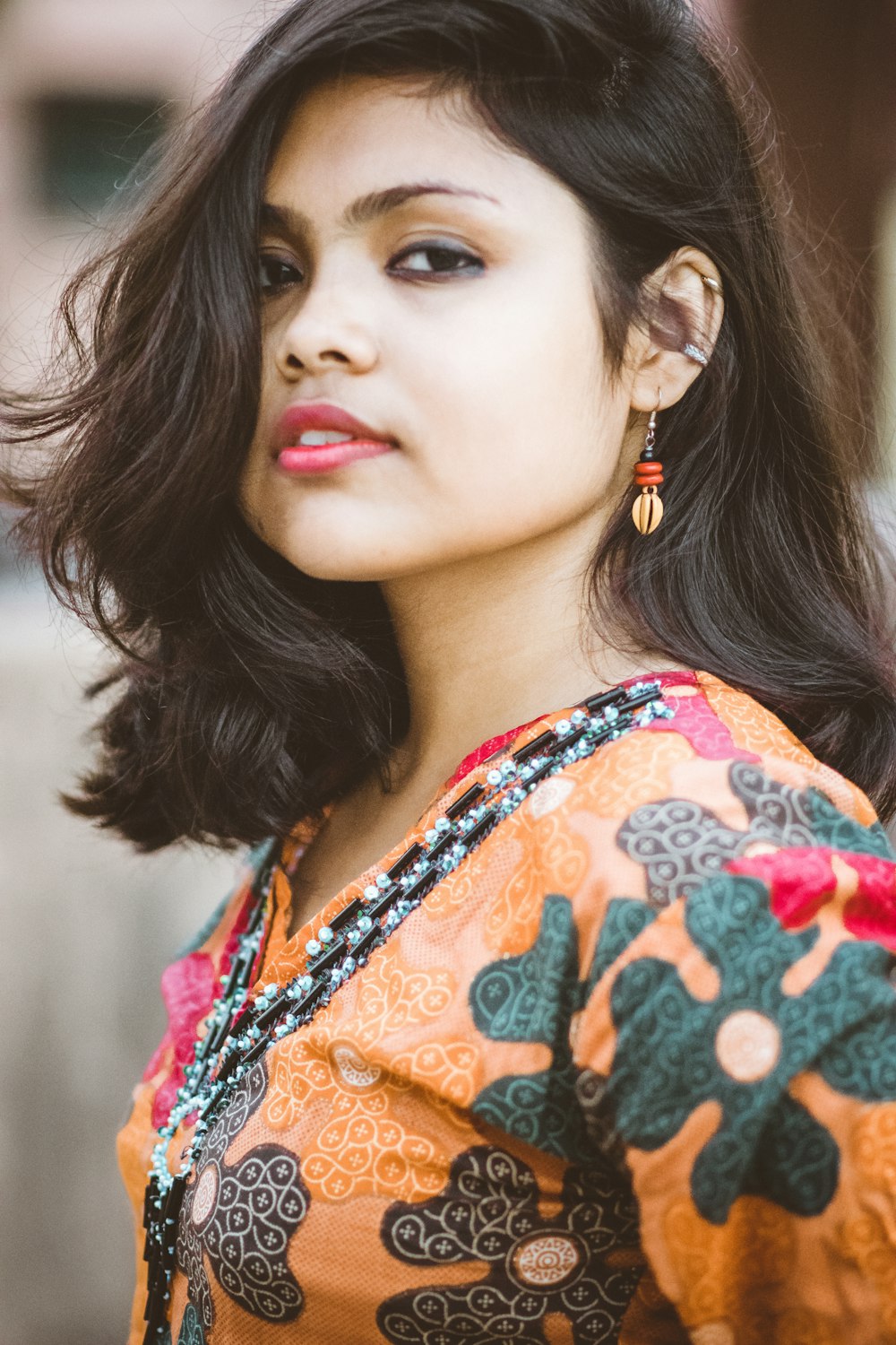 woman in orange and green floral dress