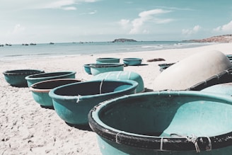 Traditional round basket boat floating on calm blue sea with fishermen.
