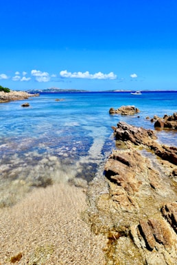 Sardinia's Emerald Coast at sunset, turquoise waters lapping against pristine white sandy beaches, l